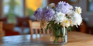 Mixed chrysanthemum bouquet in glass vase on table.