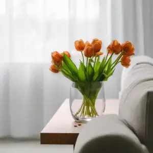 Vibrant orange tulips in glass vase