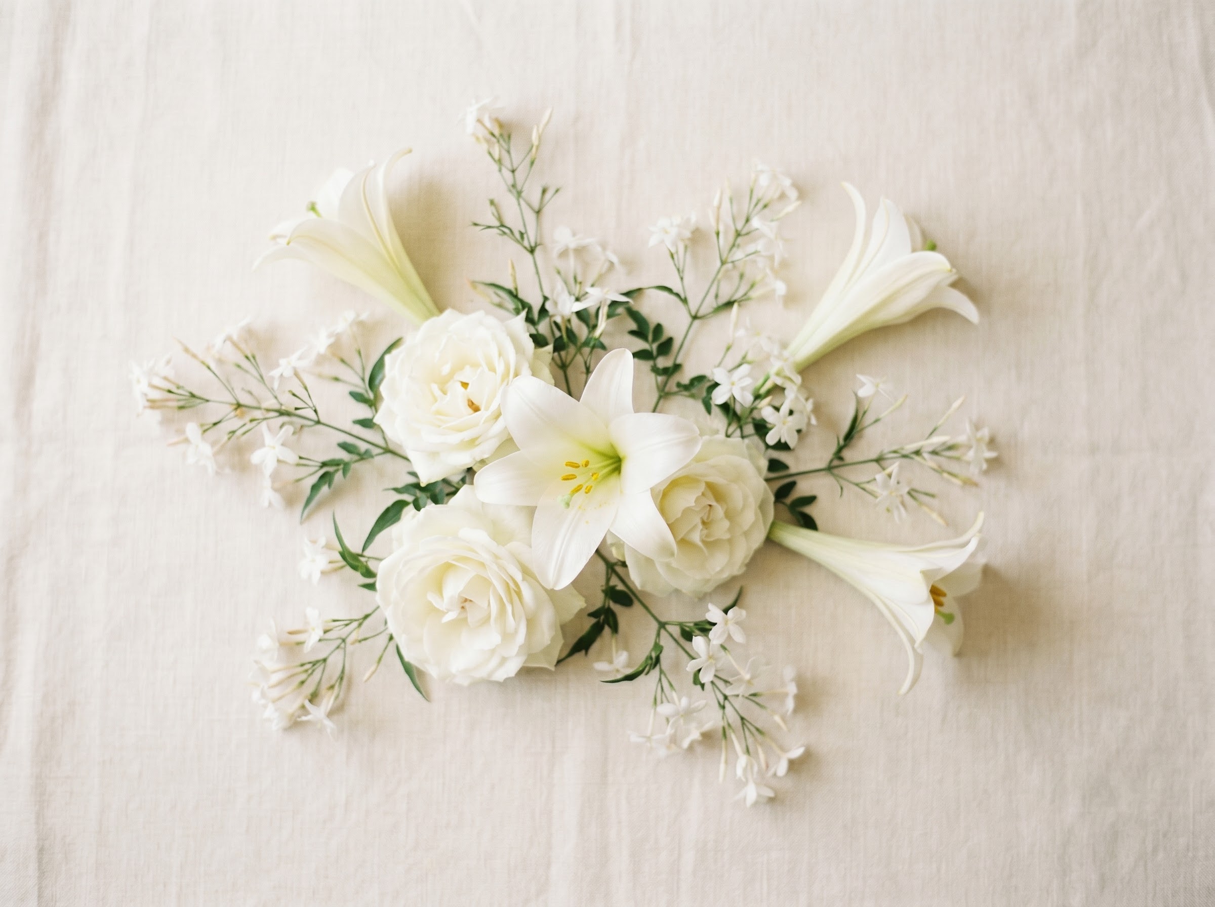 All-white arrangement of lilies, roses and jasmine showing purity and mourning duality of white flowers