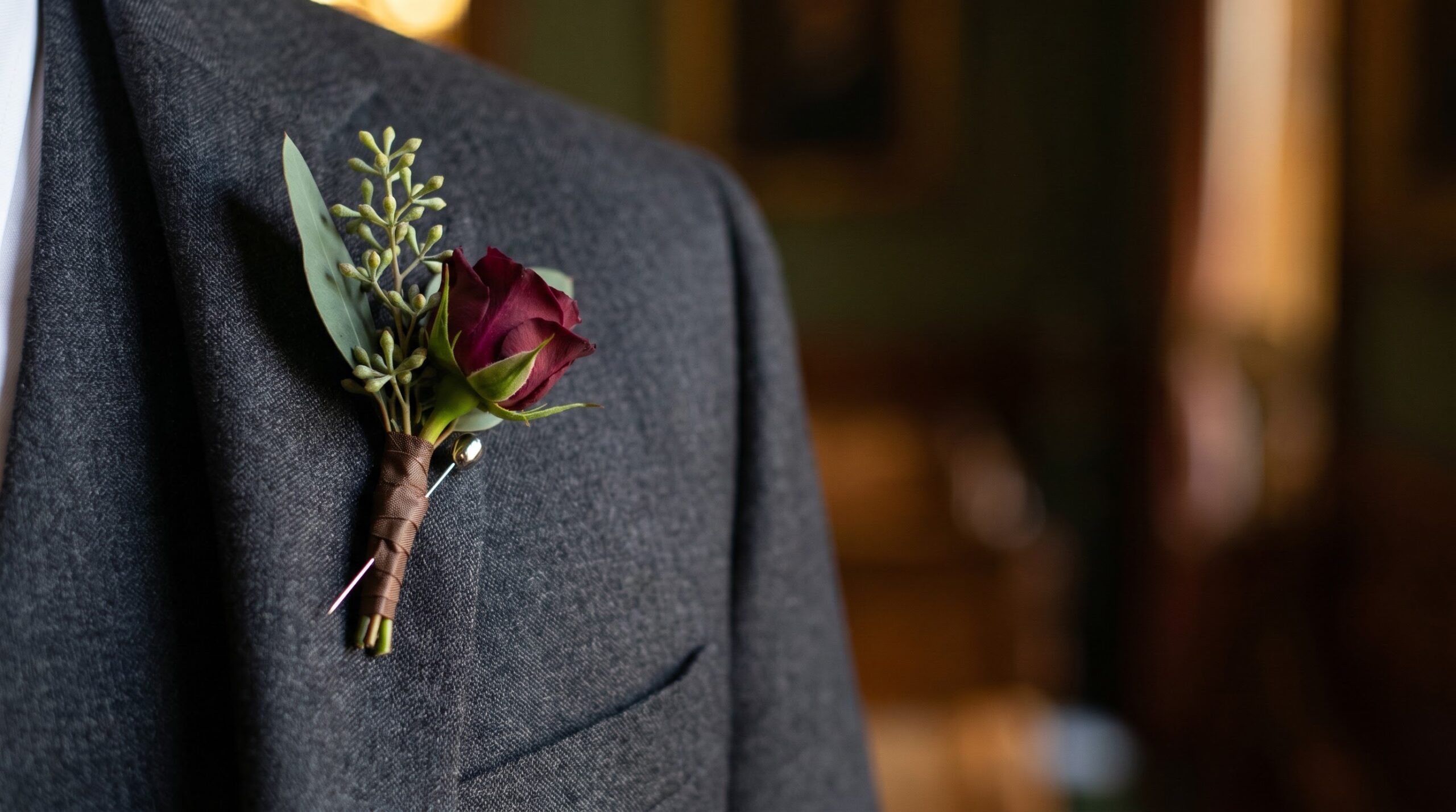 single structural boutonniere pinned to a dark graduation suit lapel