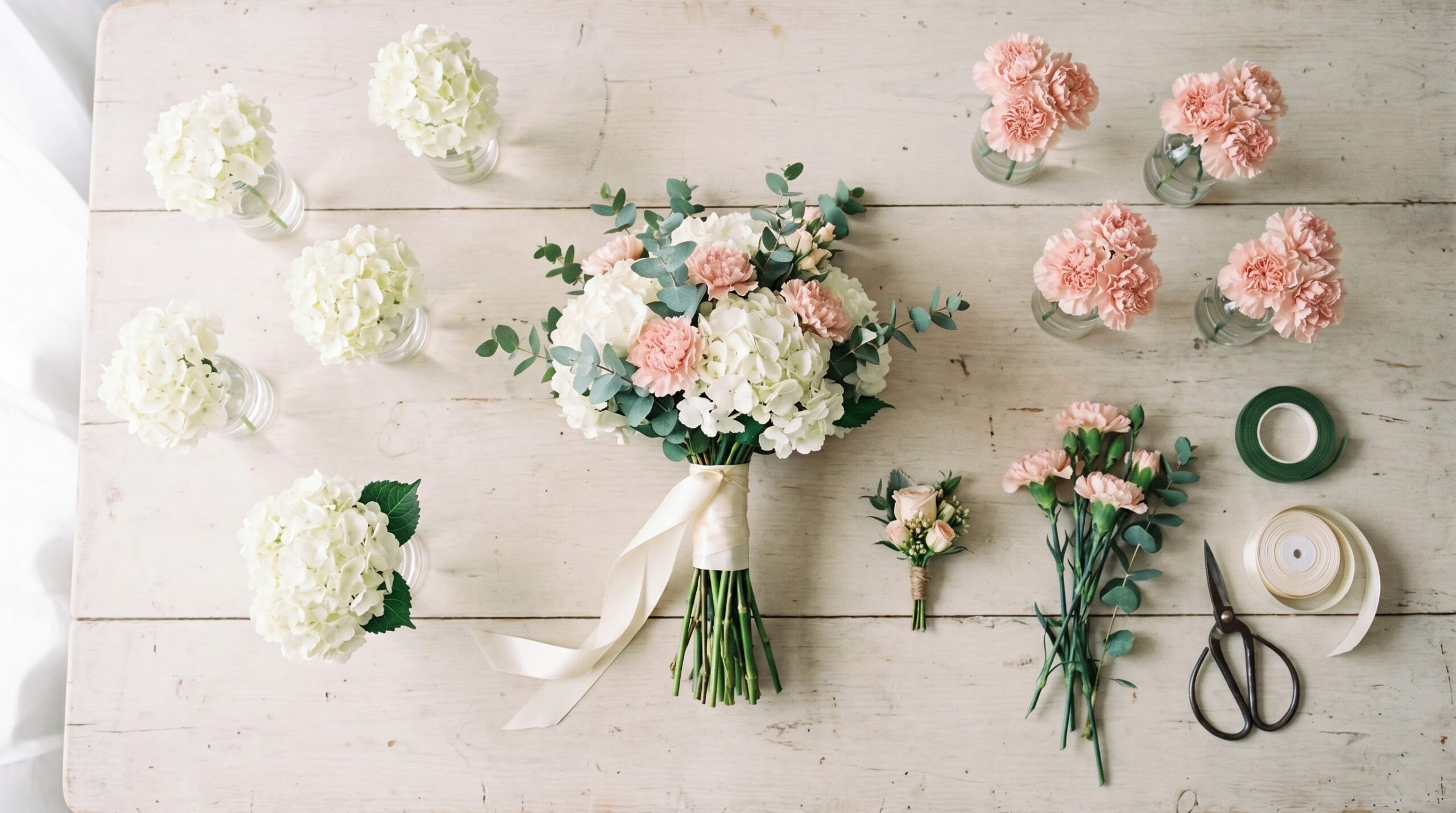 Budget wedding flower package laid flat with bouquet, boutonniere and bud vases