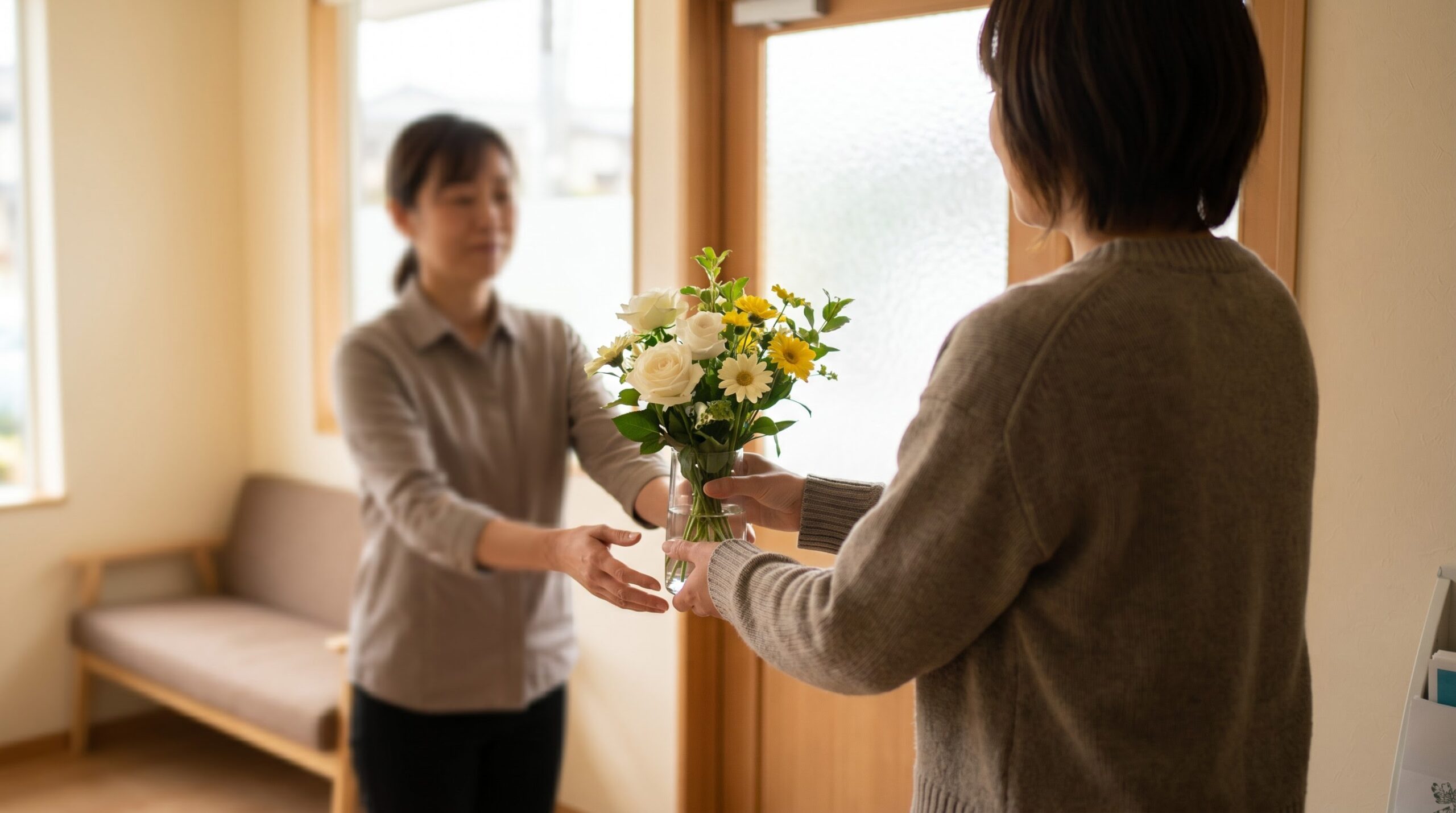 someone handing a flower arrangement to a hospice volunteer