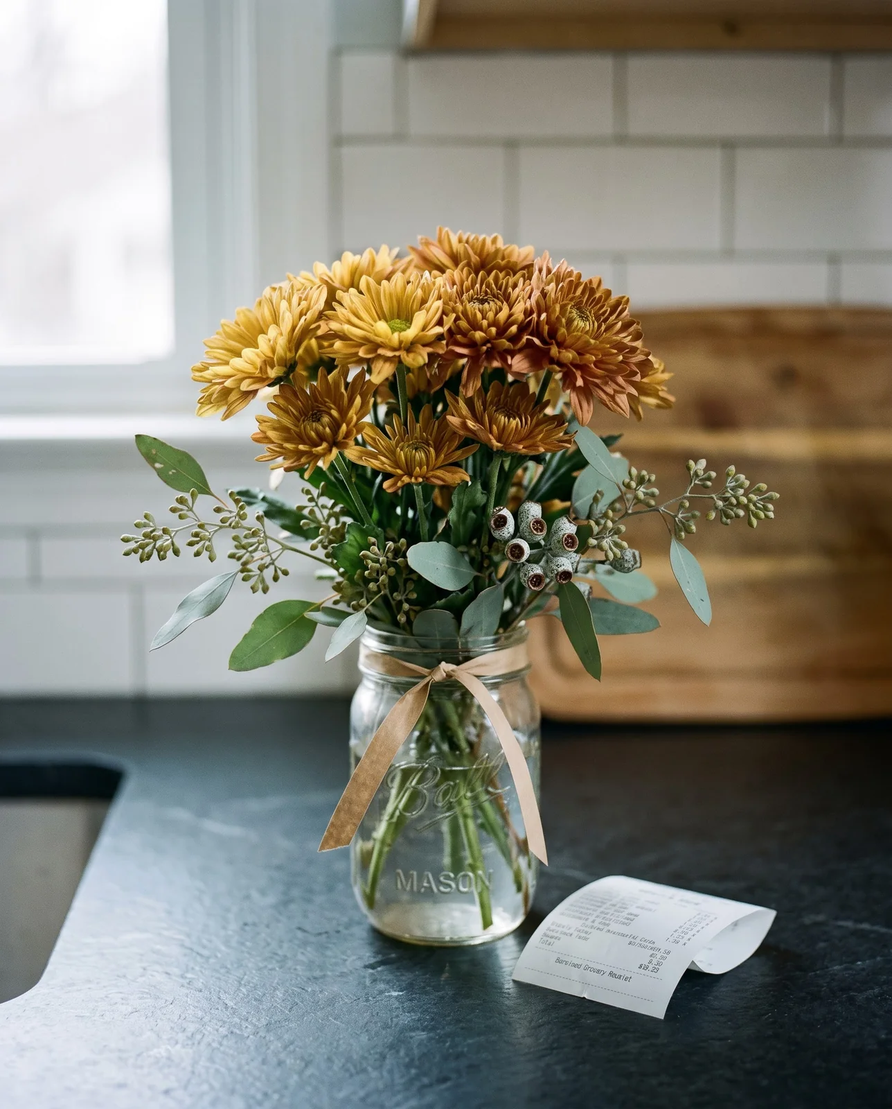 Budget mason jar Thanksgiving arrangement with yellow chrysanthemums and eucalyptus